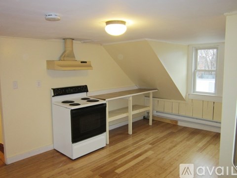 A kitchen with a stove top oven and a window.