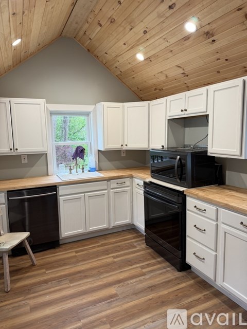A kitchen with wooden cabinets and a window.