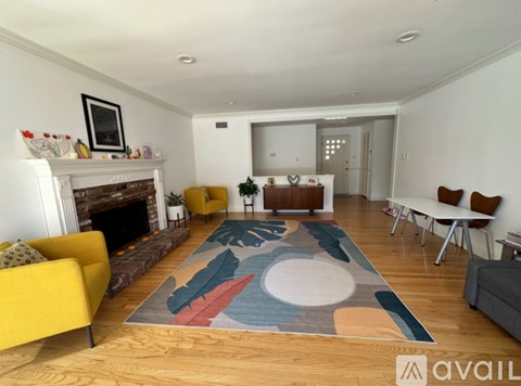 A living room with a yellow sofa and a fireplace.