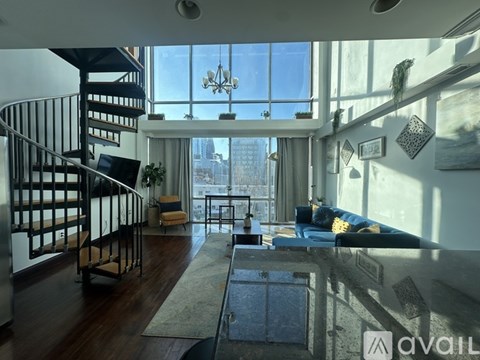 A living room with a staircase and a view of the city.