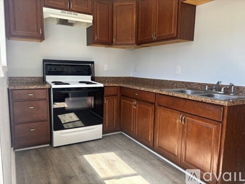 A kitchen with brown cabinets and a white oven.