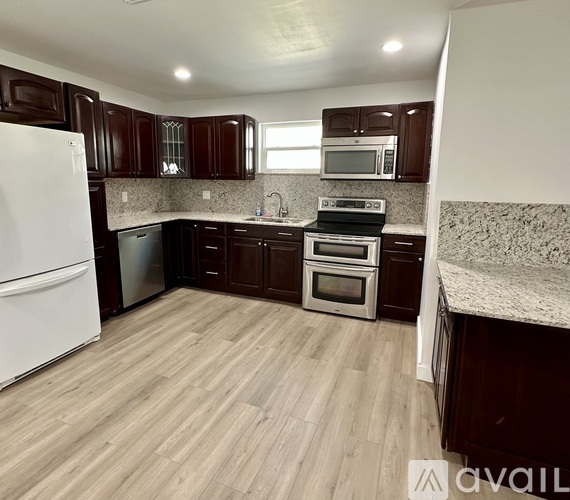 A kitchen with dark brown cabinets and a white refrigerator.