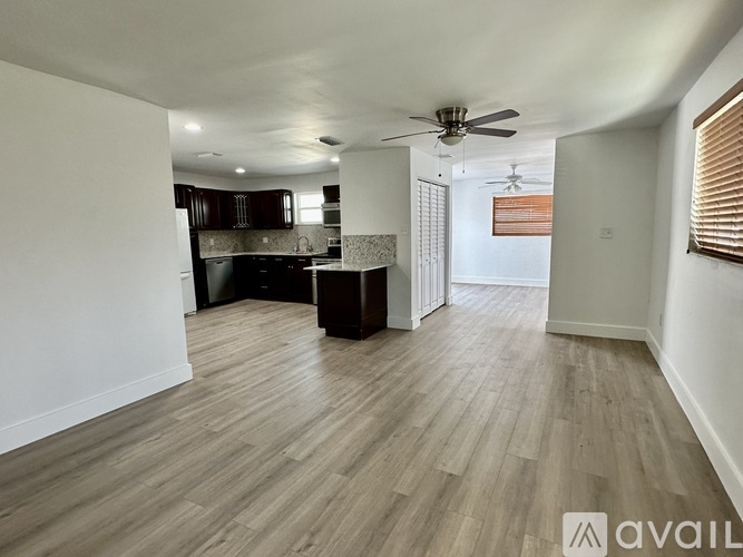 A spacious room with wooden flooring and a ceiling fan.