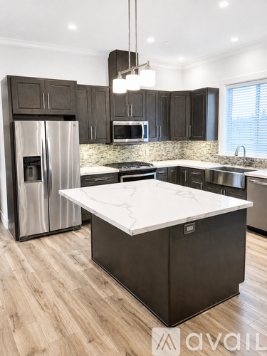 A modern kitchen with dark wood cabinets and stainless steel appliances.
