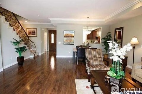 A living room with a striped couch and a coffee table with a vase of flowers on it.