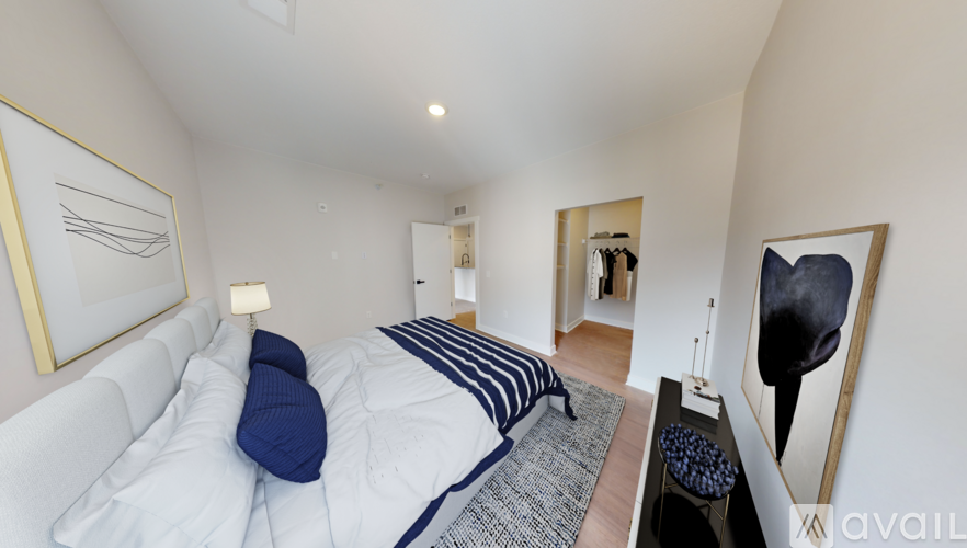 A bedroom with a bed, a nightstand, and a painting on the wall.