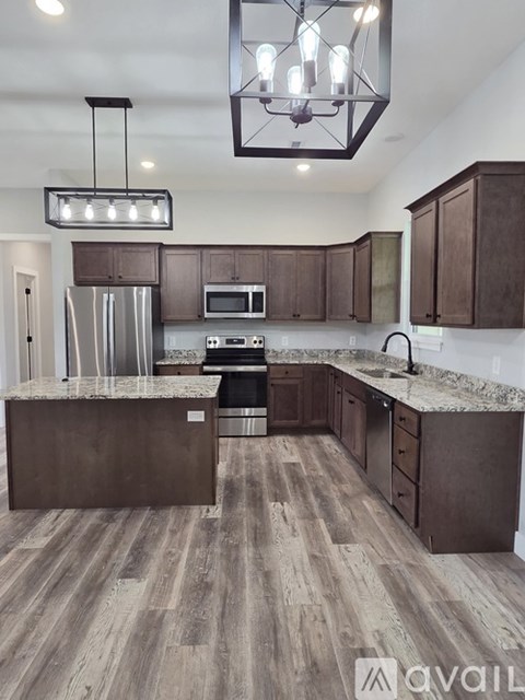 A modern kitchen with brown cabinets and a central island.