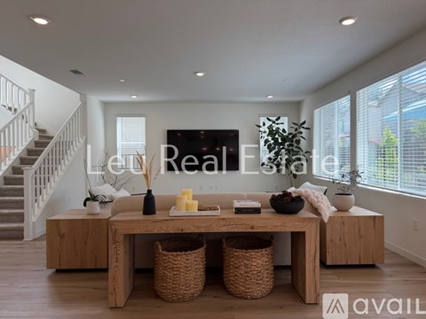 A living room with a wooden table and a staircase in the background.