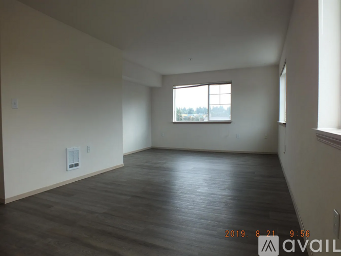 Empty room with wooden floor and a window.