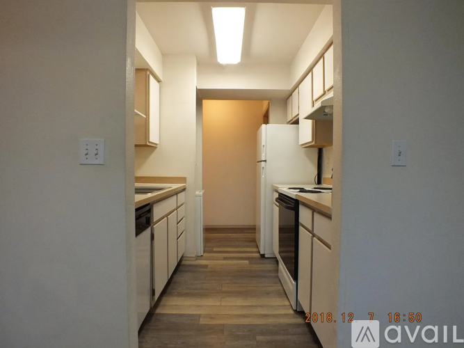 A kitchen with white cabinets and a wooden floor.