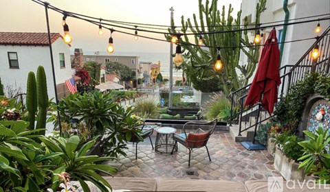 A patio with a table and chairs under string lights.