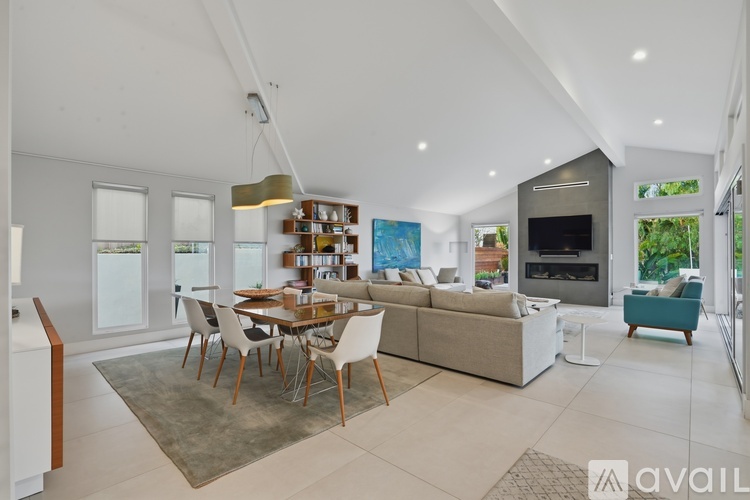 A modern living room with a dining table and chairs.