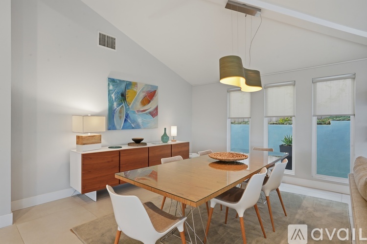 A dining room with a wooden table and chairs.