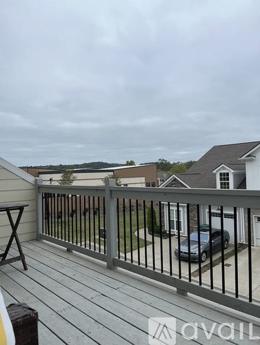 A balcony with a railing and a car parked in the driveway.