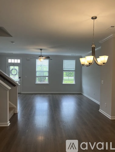 A living room with a chandelier and a window.