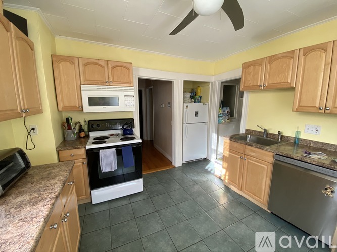 A kitchen with wooden cabinets and a tile floor.
