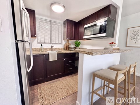 A kitchen with brown cabinets and a white fridge.