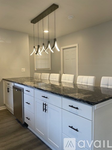 A kitchen with white cabinets and a granite countertop.