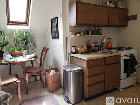 A kitchen with a stove, a table with chairs and a potted plant.