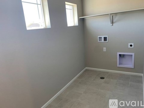A room with a window, a tile floor, and a small white cabinet.