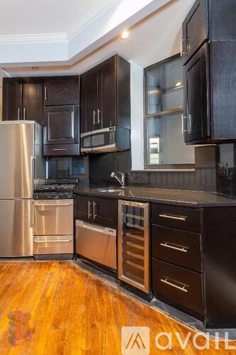 A kitchen with dark wood cabinets and stainless steel appliances.