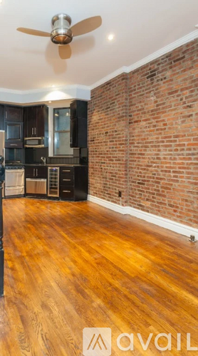 A room with wooden floors and a brick wall.