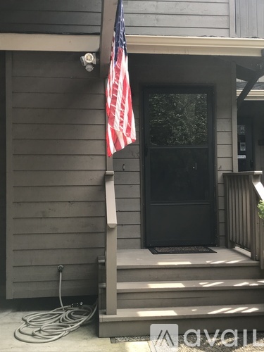 A flag is hanging on a pole outside a house.