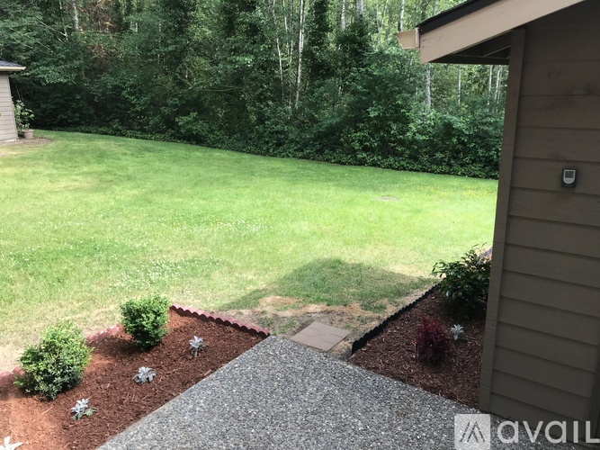 A backyard with a gravel path and a grassy area.