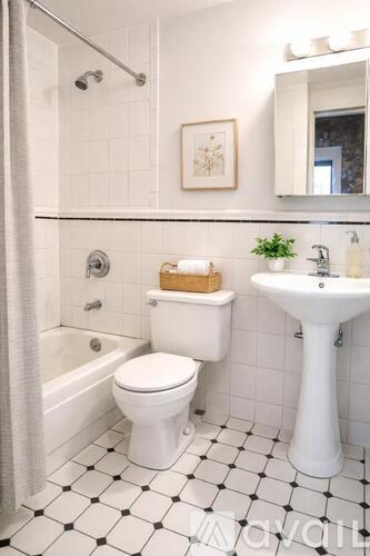 A white toilet sits next to a white sink in a bathroom.