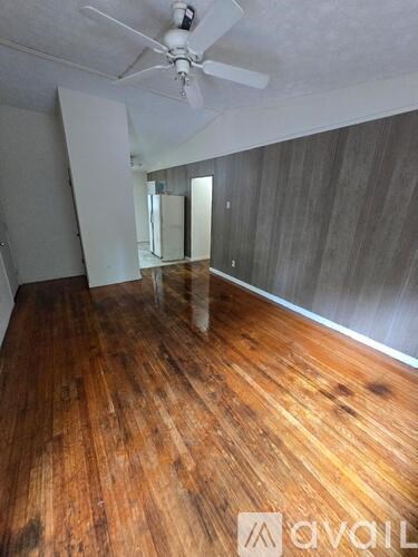 A room with wooden floors and a ceiling fan.