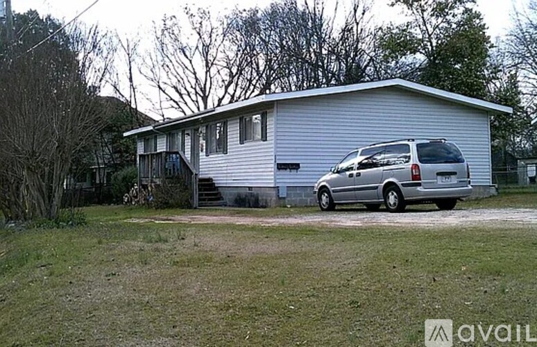 A silver van is parked in front of a house.