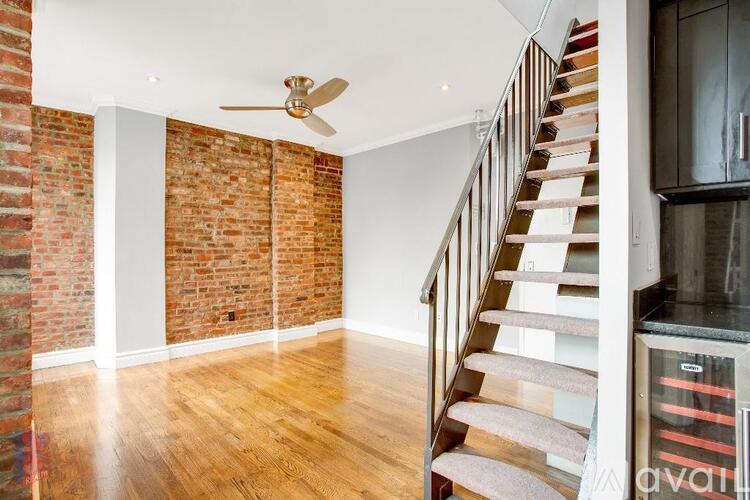 A room with a wooden floor and a staircase.