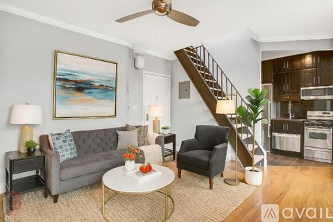 A living room with a grey couch, a coffee table, and a painting on the wall.