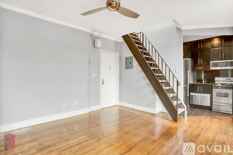 A room with a staircase leading to the kitchen.