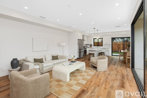 A modern living room with a checkered rug and a large window.