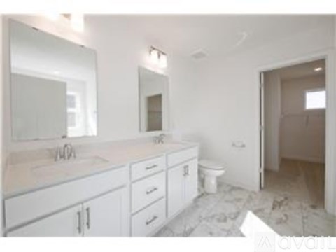 A bathroom with a sink, mirror, and toilet.
