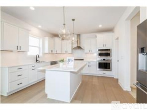 A modern kitchen with white cabinets and a central island.