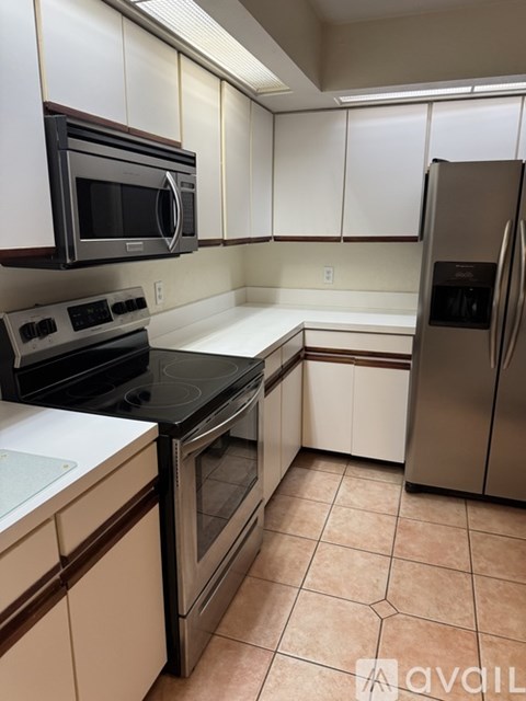 A kitchen with white cabinets and a black stove top oven.
