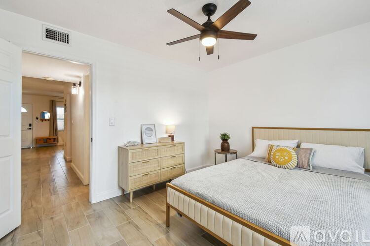 A bedroom with a bed, nightstand, and dresser.