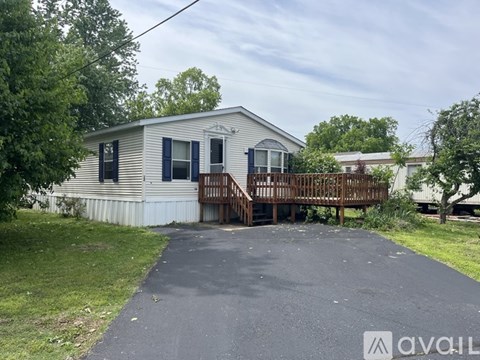 A mobile home with a deck and a driveway.