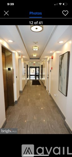 A long hallway with doors on both sides and a painting on the wall.