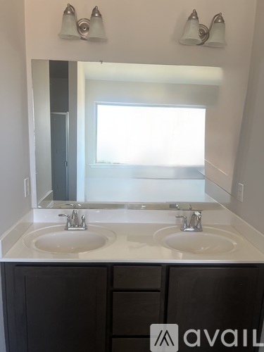 A bathroom with two sinks and a large mirror.