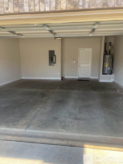 A garage with a white door and a concrete floor.