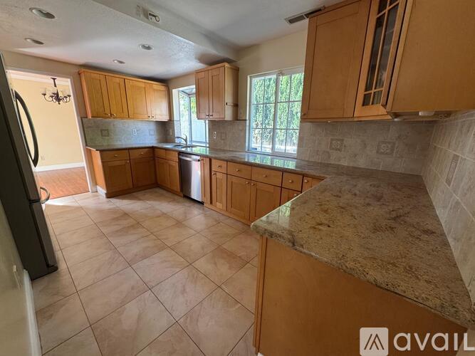 A kitchen with wooden cabinets and a granite countertop.