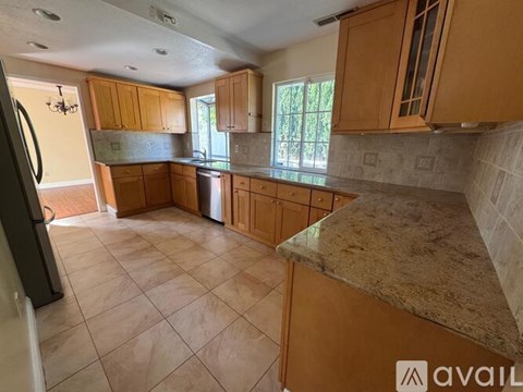 A kitchen with wooden cabinets and a granite countertop.