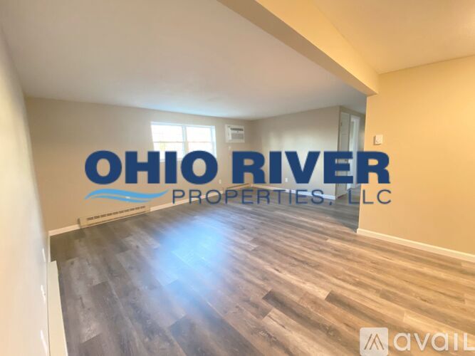A room with a wooden floor and a wall with the text "OHIO RIVER PROPERTIES, LLC" on it.