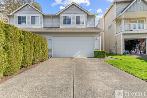 A house with a garage and a driveway in front.