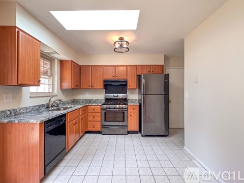 A kitchen with wooden cabinets and black appliances.