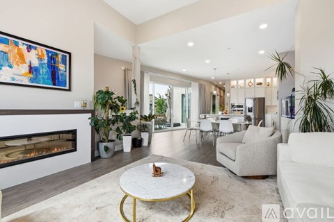 A modern living room with a fireplace and a painting on the wall.