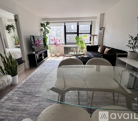A modern living room with a glass table and grey chairs.